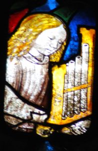 The angel with the portative organ in Window 23 of St Mary's Church, Fairford